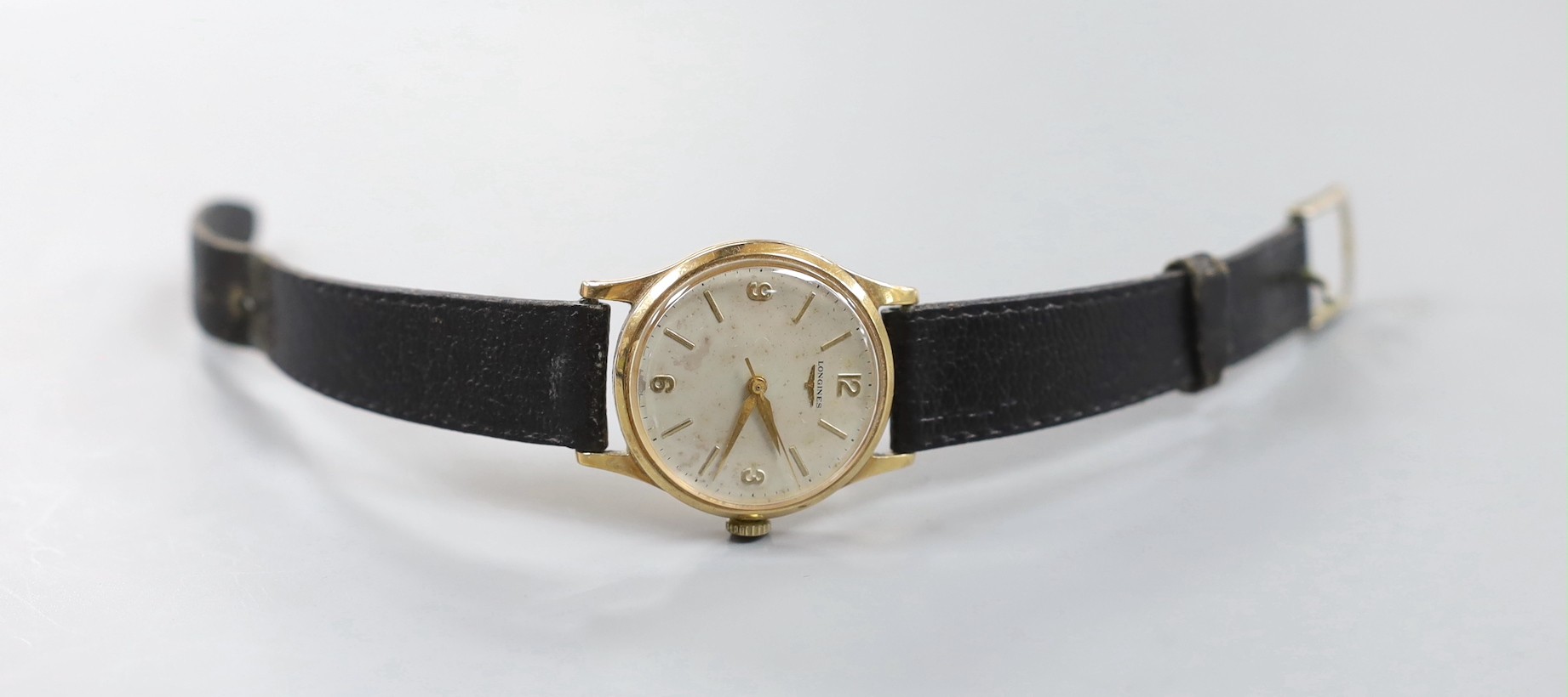 A gentleman's 1960's 9ct gold Longines manual wind wrist watch, with case back inscription, case diameter 33mm, on associated leather strap, gross weight 36.5 grams.